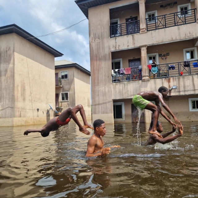 Des personnes jouant dans les eaux de crue à l'extérieur de Dorca Executive Apartments (logement pour étudiants) dans la municipalité d'Ogbia, État de Bayelsa, Nigeria - novembre 2022.