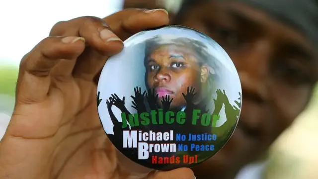Nikki Jones muestra una insignia con la imagen de Michael Brown que fue baleado de muerte en Ferguson, Misuri.