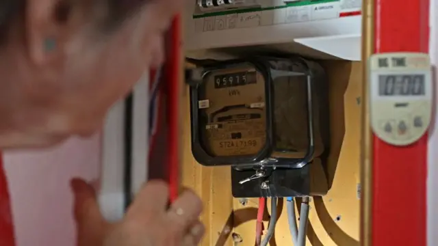 Mujer mirando el contador de la luz.