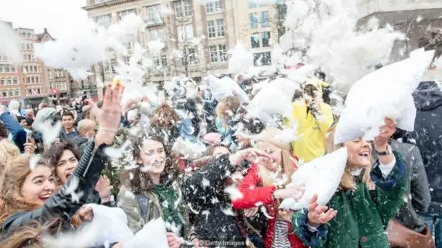 Bulu-bulu beterbangan di Dam Square di Amsterdam saat orang-orang berpartisipasi dalam Hari Perang Bantal Internasional.