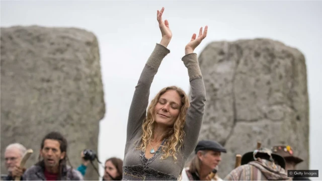 Une femme danse alors que druides, païens et fêtards se rassemblent à Stonehenge