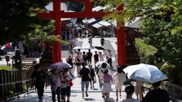 AUGUST 08: Tourists walk through a Torii gate at the Fushimi Inari shrine on August 08. 2024 in Kyoto, Japan. The Japan National Tourism Organization released on July 19 that more than 17.7 million foreign visitors entered Japan from January through June this year, recording the highest number for the first half of a year. (Photo by Tomohiro Ohsumi/Getty Images)