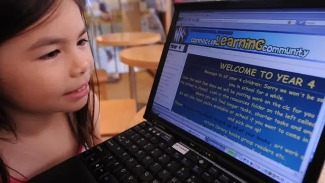 เด็กนักเรียนประถมดูหน้าเว็บไซต์ของโรงเรียน