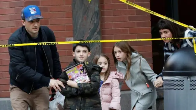 Niños y adultos pasan por los cordones policiales