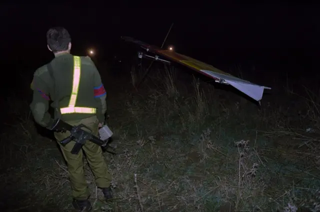 An Israeli soldier looks at the motorized hang glider used in a suicide attack on 26 November 1987, at a military camp near Kiryat Shmona in northern Israel, where six Israeli soldiers were killed and seven wounded
