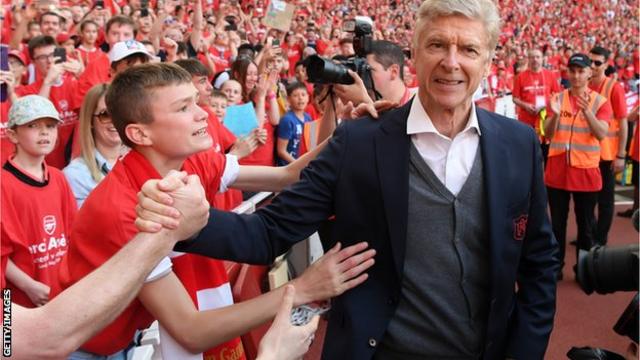 Wenger gives his red club tie to one young fan after his post-match presentation