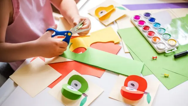 Una niña recortando figuras de papel