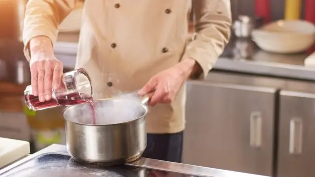 Повар готовит винный соус