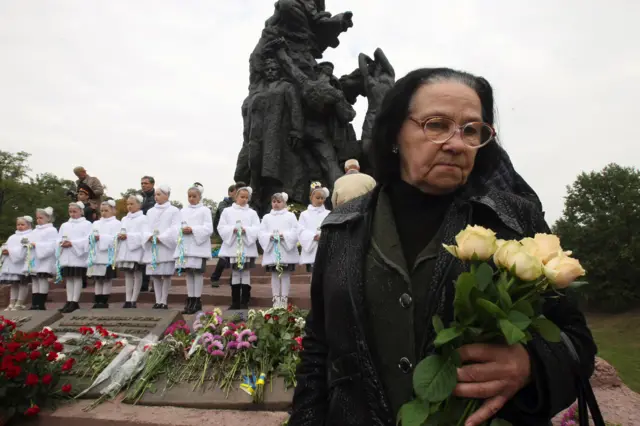 Жінка біля пам'ятника у Бабиному Яру