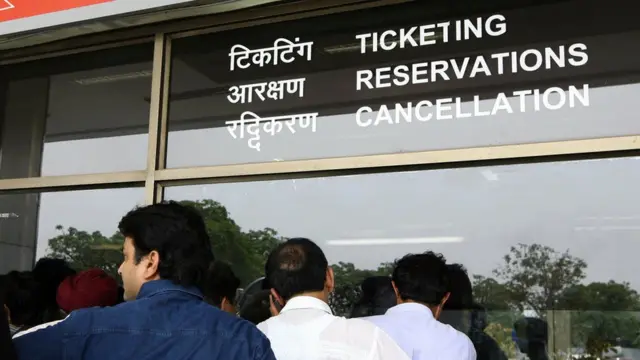 ઍરલાઇન કંપનીની ટિકિટબારી પર લાઇનમાં ઊભેલા લોકો