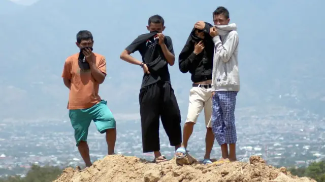 Warga menyaksikan proses pemakaman massal korban gempa Palu di TPU Poboya Indah, Palu, Sulawesi Tengah, Selasa (02/10.