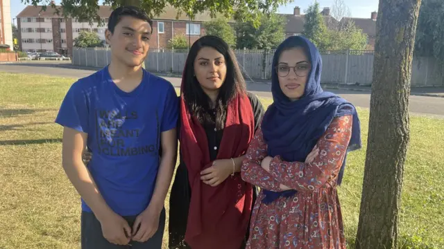 Shabhnam and siblings standing in their local park in North London