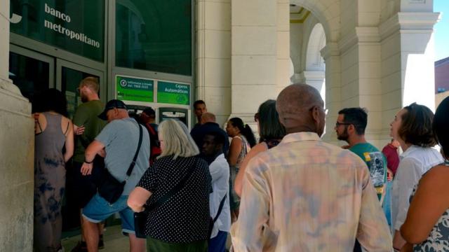 Cubanos y extranjeros en un banco de Cuba
