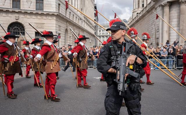 Рота копьеносцев и мушкетеров в старинных костюмах марширует под охраной вооруженной полиции у здания Банка Англии, 9 сентября 2022 года