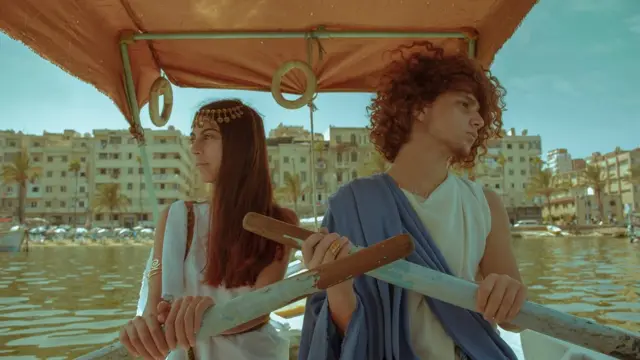 شاب وفتاة في زي روماني داخل قارب