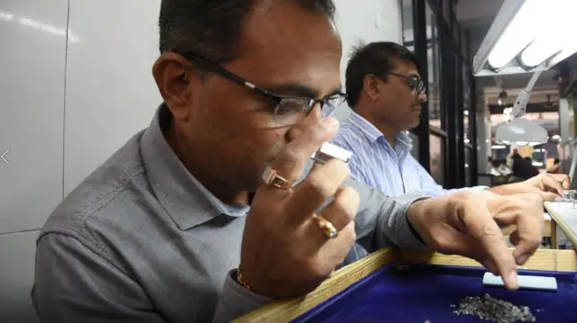 हिऱ्याची पारख करताना व्यापारी