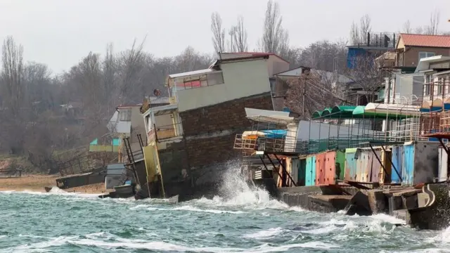 Casas sendo derrubadas por ondas