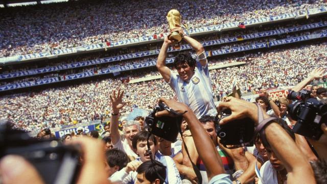 Argentina Captain Diego Maradona holds the World Cup trophy whilst being carried on his team-mates' shoulders after the 1986 FIFA World Cup Final