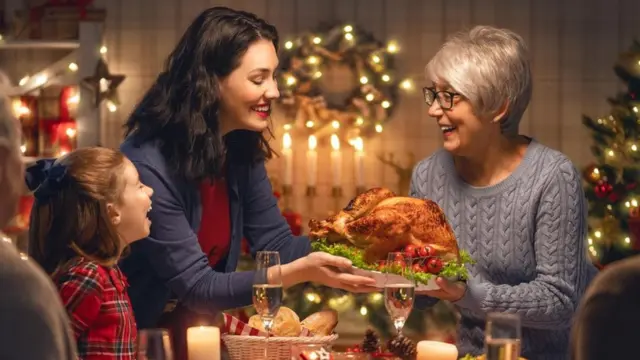 Familia compartiendo comida durante la cena navideña.