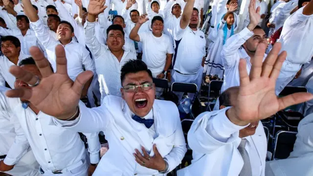 Hombres gritando con los brazos alzados.