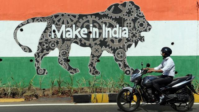 Motociclista passa perto de grafite com os dizeres "Made in India" em Mumbai, em fevereiro