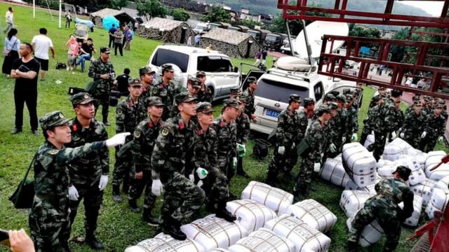 Paramilitary police unload disaster relief packages from a truck at a temporary settlement after the earthquake in Changning county, Sichuan province, China, 18 June 2019