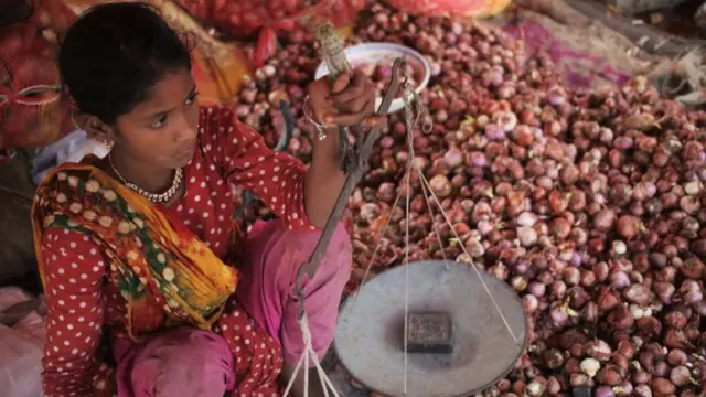 ঢাকার একটি বাজারে পেঁয়াজ বিক্রি করছেন এক বিক্রেতা