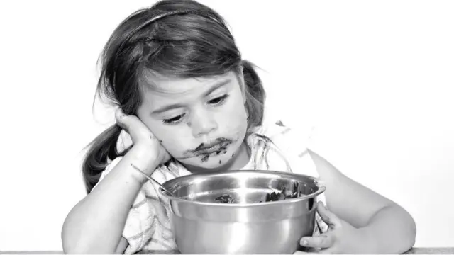 طفلة حزينة تأكل كعك