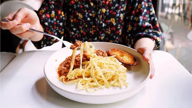 Mulher comendo macarrão