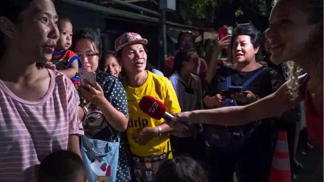 ผู้สื่อข่าวจากสำนักข่าวต่างประเทศขณะสัมภาษณ์ชาวบ้านที่รอต้อนรับขบวนรถพยาบาล