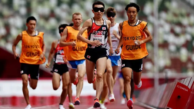 okyo 2020 Paralympic Games - Athletics - Men's 1500m - T11 Final - Olympic Stadium, Tokyo, Japan - August 31, 2021. Shinya Wada of Japan and guide Takumi Hasebe in action REUTERS/Athit Perawongmetha