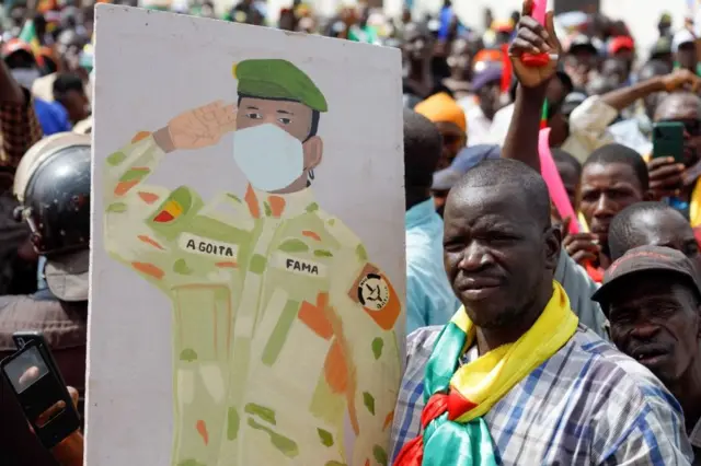Un partisan du président intérimaire malien Assimi Goita brandit son image lors d'un rassemblement pro-junte et pro-russe à Bamako, le 13 mai 2022. - Plusieurs centaines de Maliens se sont rassemblés à Bamako pour soutenir la junte, l'armée et la coopération militaire avec les Russes, rapportent des journalistes de l'AFP