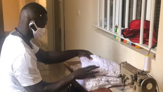 Khadim Diop en train d'emballer ses masques avant de les livrer