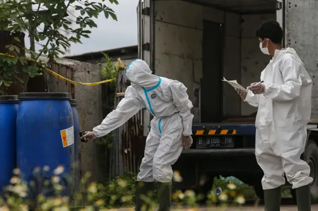 Dua anggota berbaju khusus sedang meneliti keberadaan radiasi.