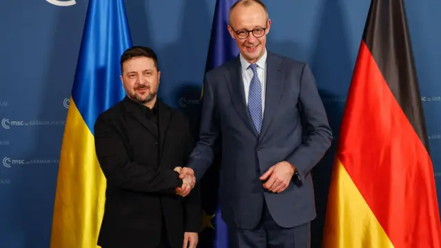 الرئيس الأوكراني فولوديمير زيلينسكي (يسار) والمستشار الألماني فريدريش ميرتس يتصافحان قبيل محادثات ثنائية خلال الدورة الثانية والستين من مؤتمر ميونيخ للأمن.