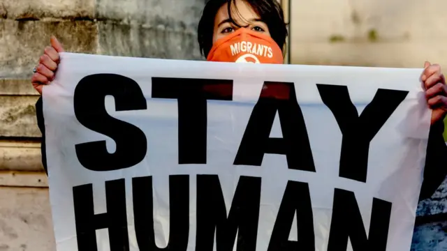 ইটালিতে অভিবাসীদের আশ্রয় দেওয়ার পক্ষে বিক্ষোভ করছেন এক নারী