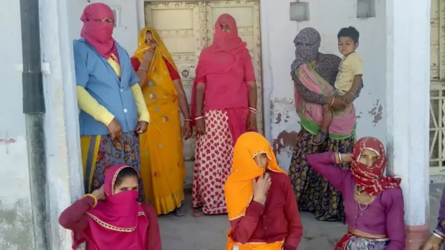 आशा सहयोगिनी संपत महिलाओं से बात कर उन्हें कोरोना वायरस के बचाव के तरीके समझा रही हैं.