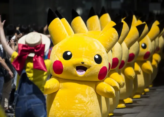 Performers dressed as Pikachu, a character from Pokemon series game titles, march during the Pikachu Outbreak event, 9 August 2017.