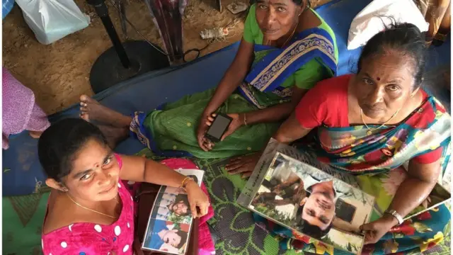 પોતાના પરિજનોની તસવીરો સાથે મહિલાઓ