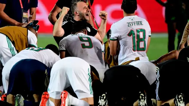 L'entraîneur algérien Djamel Belmadi (en noir) fête avec ses joueurs la victoire contre le Nigeria en demi-finale de la CAN.