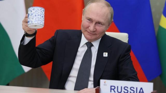 俄罗斯总统普京在莫斯科出席金砖五国领导人虚拟峰会时举起茶杯致意（23/6/2022）
