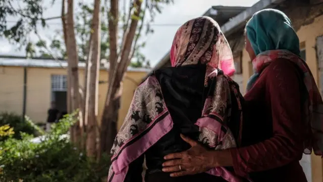 ሁለት ጀርባቸውን ሰጥተው የቆሙ ግለሰቦች