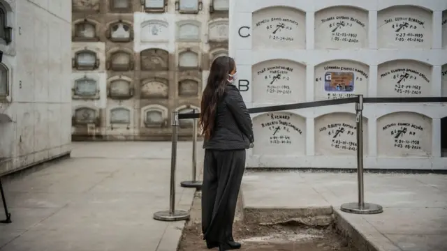 Mulher chora durante o sepultamento de um parente