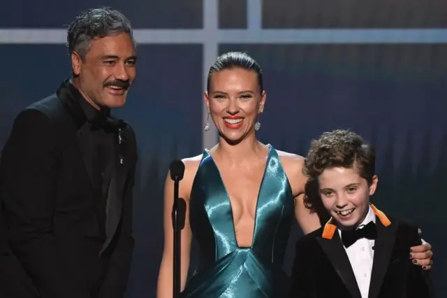 Автор сценария и режиссер фильма "Кролик Джоджо" Тайки Вайтити с исполнетелями главных ролей Скарлет Йохансон и Роман Гриффин Дэвис на презентации фильма в Лос-Анджелесе. 19 января 2020 г.