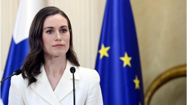 Uma mulher branca,ferramenta de análise fifa bet365lábios finos, olhos azuis e cabelos castanhos no ombro, vestindo um blazer branco, estáferramenta de análise fifa bet365pé, olhando para a frente,ferramenta de análise fifa bet365frente a uma bandeira azul com estrelas amarelas (da união europeia) e uma bandeira da finlândia (branca com cruz azul)