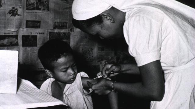 Una enfermera administra la vacuna BCG a un niño en Vietnam en la década del 50.