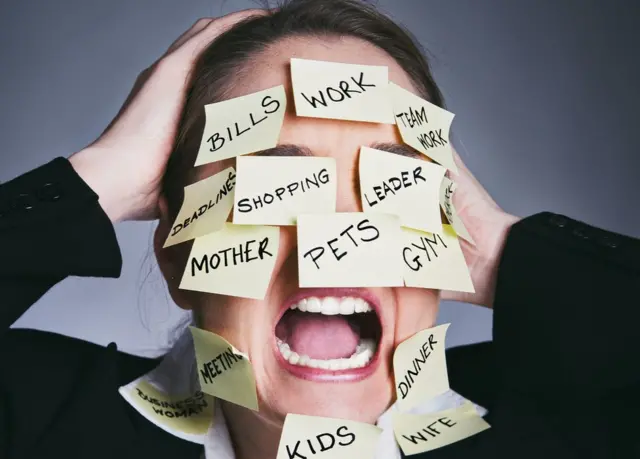 Mujer con notas en la cara en las que se leen las tareas que tiene que hacer.
