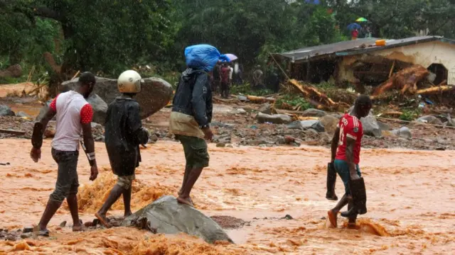 Afectados caminan entre la inundación.