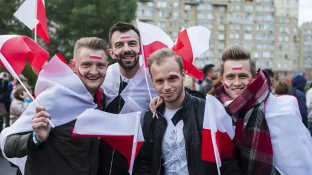 Молоді поляки із національними прапорами