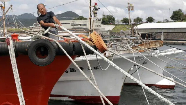 A fisherman tighten a rope to anchor his fishing boat with his colleague's boats in preparation for powerful typhoon Haishen in Makurazaki, Kagoshima Prefecture, Japan, 05 September 2020